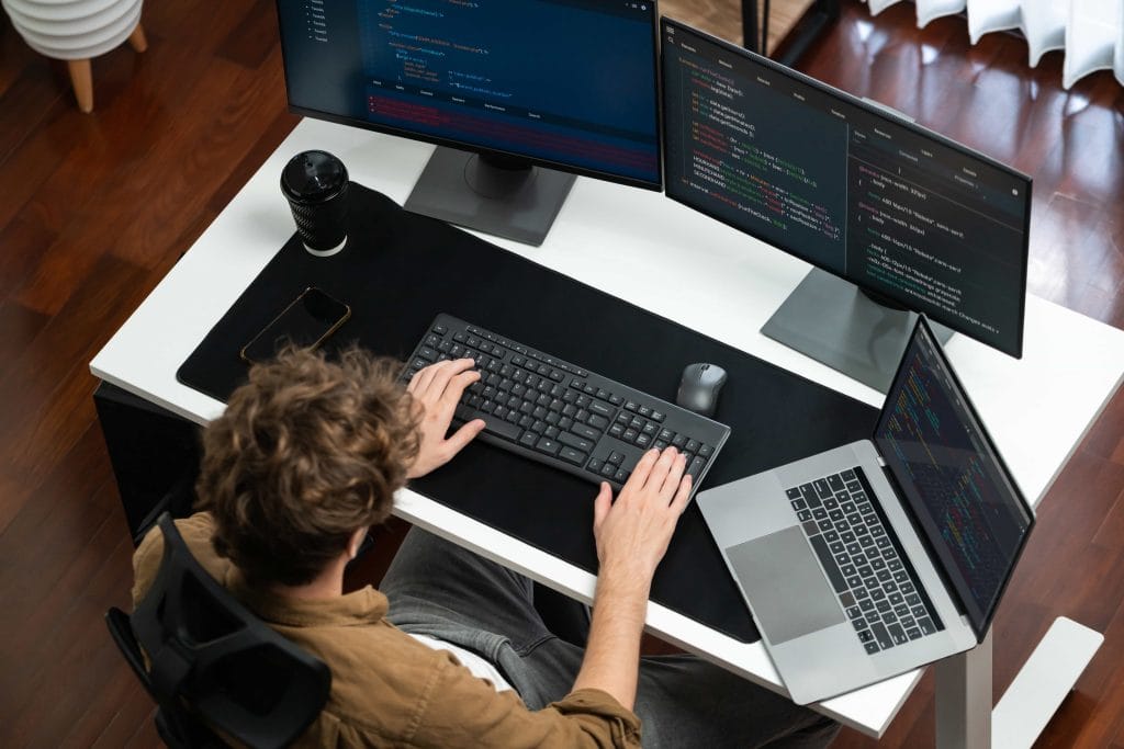 developer reviewing code on large monitor